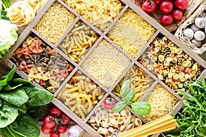 Different types of italian uncooked pasta in wooden box, whole wheat pasta, pasta, spaghetti, noodles, tagliatelle. Top view