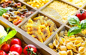 Different types of italian uncooked pasta in wooden box, whole wheat pasta, pasta, spaghetti, noodles, tagliatelle. Top view