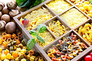 Different types of italian uncooked pasta in wooden box, whole wheat pasta, pasta, spaghetti, noodles, tagliatelle. Top view