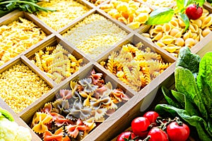 Different types of italian uncooked pasta in wooden box, whole wheat pasta, pasta, spaghetti, noodles, tagliatelle. Top view