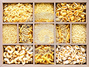 Different types of italian uncooked pasta in wooden box, whole wheat pasta, pasta, spaghetti, noodles, tagliatelle. Top view