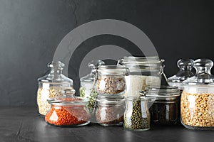 Different types of legumes and cereals on grey table. Organic grains