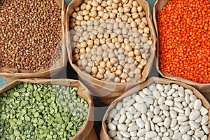 Different types of legumes and cereals in paper bags