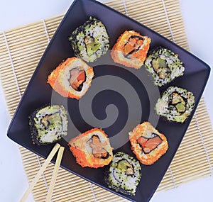 Different types of Maki sushi on a black plate