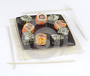 Different types of Maki sushi on a black plate
