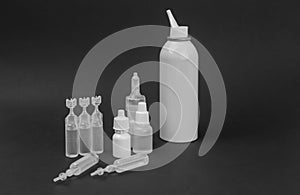 Different types of medical drops, nasal spray and nasal spray on black background. Sanitation of the nose, rinsing. Viruses.