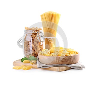 Different types of pasta and basil  isolated on white