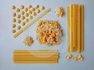 Different types of pasta, blue background. Food knolling, top view.