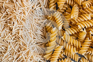 Different types of pasta on a stone background