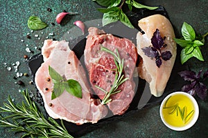 Different types of raw Fresh Meat, chicken fillet, pork and beef in a cast-iron grill pan