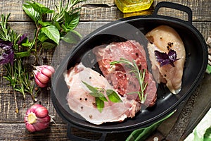 Different types of raw Fresh Meat, chicken fillet, pork and beef with vegetables and herbs