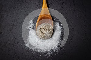 Different types of salt. Salt with spices and pure salt on a dark background.