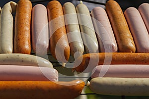 Different types of sausages on the grill board are prepared for frying