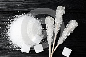 Different types of sugar on black wooden table