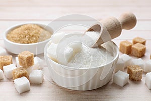 Different types of sugar on white wooden table, closeup