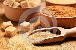 Different types of sugar on wooden table, closeup