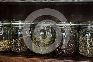 Different types of teas in glass jars on a shelf