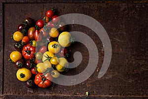 Different types of tomatoes on rusty background
