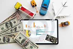 different types of toy cars and a tablet, money