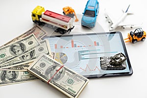 different types of toy cars and a tablet, money