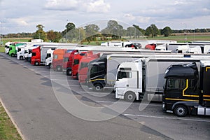 Different types of trucks in a crowded parking lot off the highway