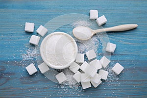 Different types of white sugar on light blue wooden table, flat lay