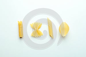 Different uncooked pasta on white background, top view