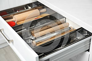 Different utensils in open desk drawer