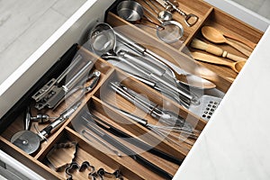 Different utensils in open desk drawer, closeup