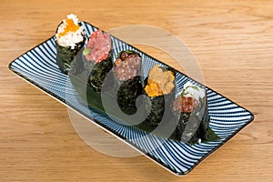 Different varieties of gunkan wrapped in nori seaweed, bluefin tuna tartare, caviar of different sizes and colours avocado, sea