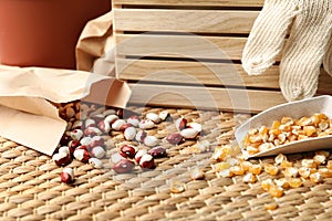 Different vegetable seeds and wooden crate on table