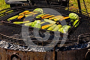 Different vegetables cooking on a grill at country fair