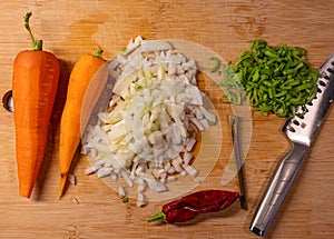 Different vegetables and knife on bamboo cutting board