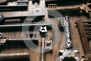 Different vintage metal keys on a wooden background