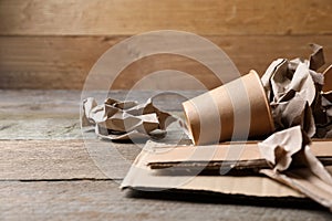 Different waste paper on wooden table, closeup. Space for text