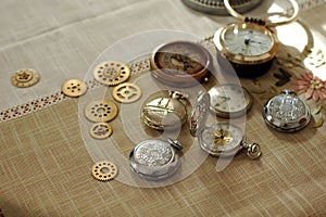 Different watches and cogwheels, gearwheels in steampunk style on a table