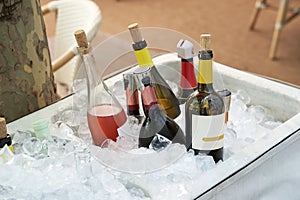 Different wine bottles set in ice bucket on a summer terrace of a restaurant.