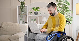 Differently abled man on wheelchair working with laptop