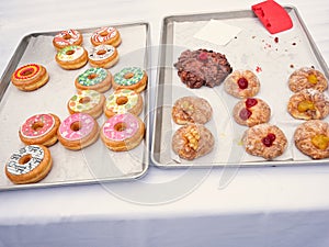 Differently decorated donuts on a baking tray