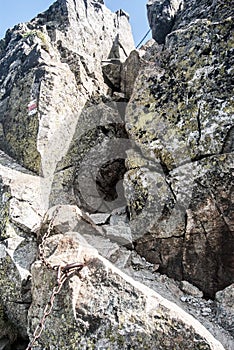 Difficult hiking trail secured by chain on Tri kopy peak in Western Tatras mountains in Slovakia