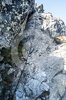 Obtížná turistická stezka po skalách zajištěných řetězem vede na vrchol Baníkov v Západních Tatrách na Slovensku