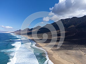 Difficult to access golden sandy Cofete beach hidden behind mountain range on Fuerteventura, Canary islands, Spain