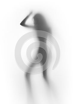 Diffuse silhouette of a slim lady, behind a glass surface photo