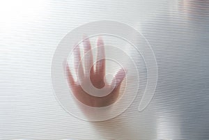 Diffused silhouette of female hands through plastic