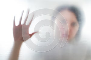 Diffused silhouette of female hands, view with shadow through plastic