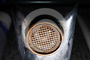 The diffuser in the faucet is clogged and corroded close-up. Old plumbing fixtures in the house