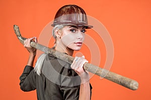 dig deeper. woman in boilersuit and helmet. female builder hold shovel.