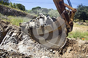 Digger bucket full of rocks