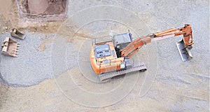 Digger excavator construction building site banner view from above miniature rubber tracks orange vehicle in operation excavating