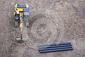 Digger excavator construction building site banner view from above miniature rubber tracks yellow vehicle in operation excavating